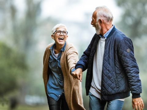 Happy older couple holds hand outdoors