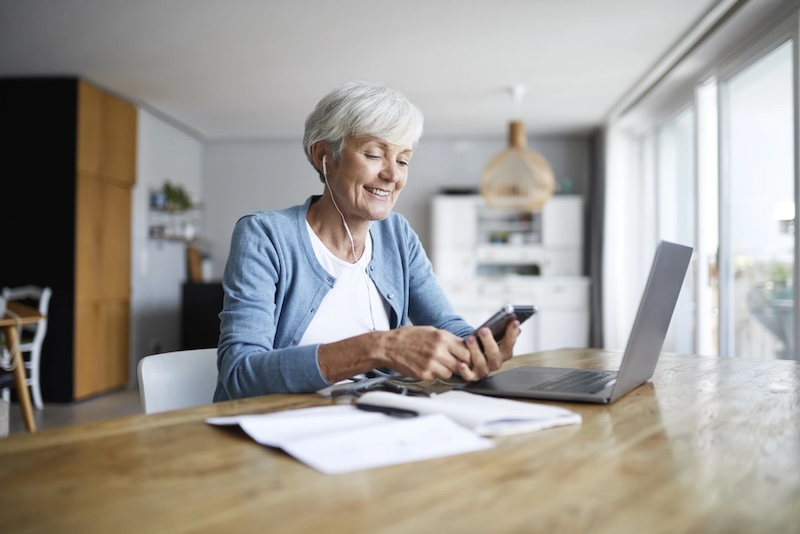 Active senior female listening to music while sitting at home