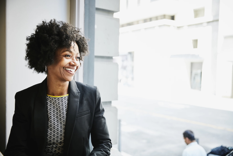 Smiling businesswoman sitting in coffee shop looking out window