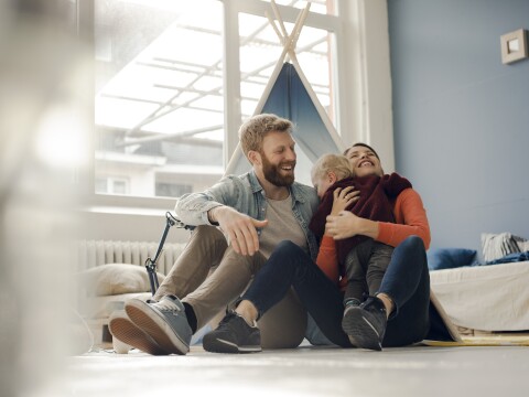 Happy family playing with their son at home