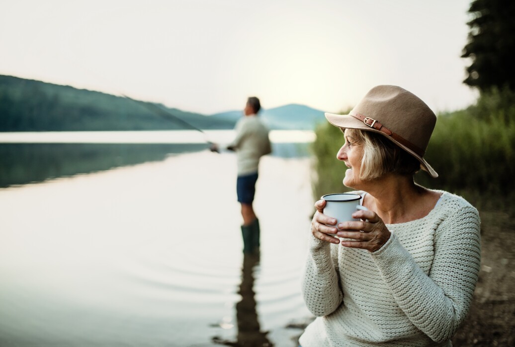 Woman having coffee by the lake