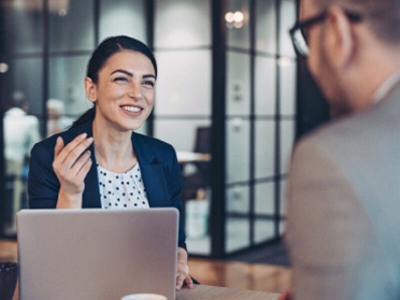 Smiling young woman talking with her coworker