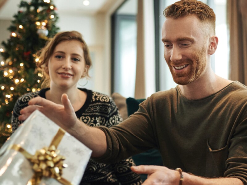 A couple shares gifts at Christmas.