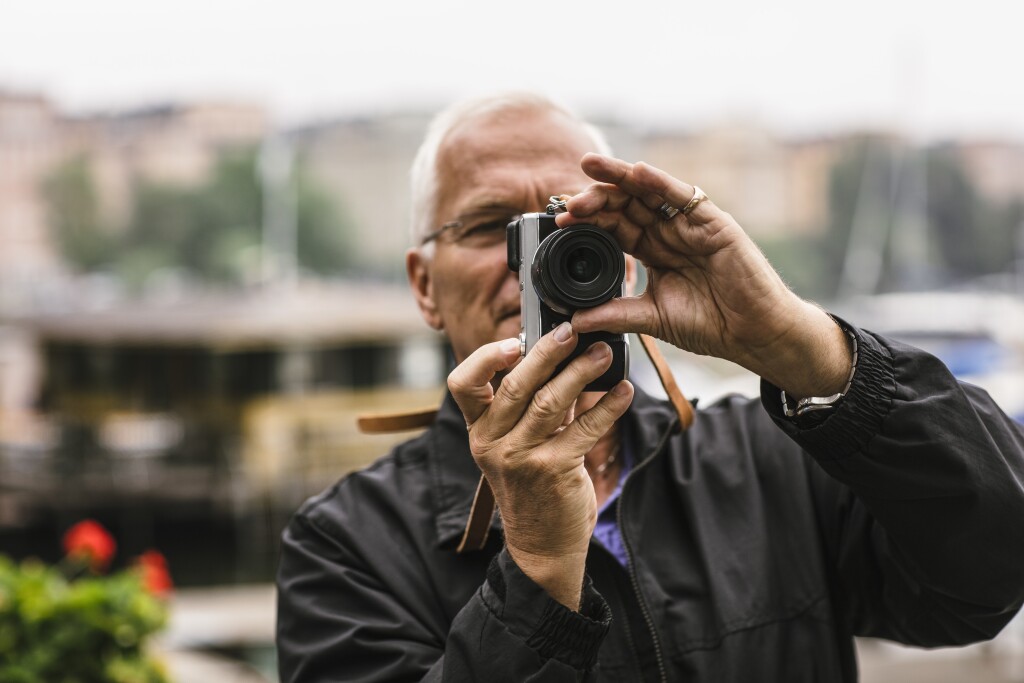 Man in 60s using camera during photography course