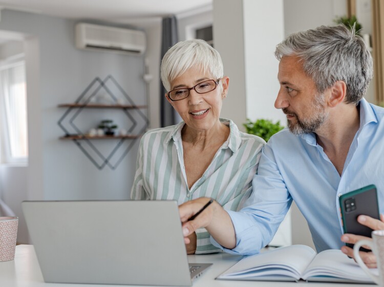 Mature couple at home using laptop together