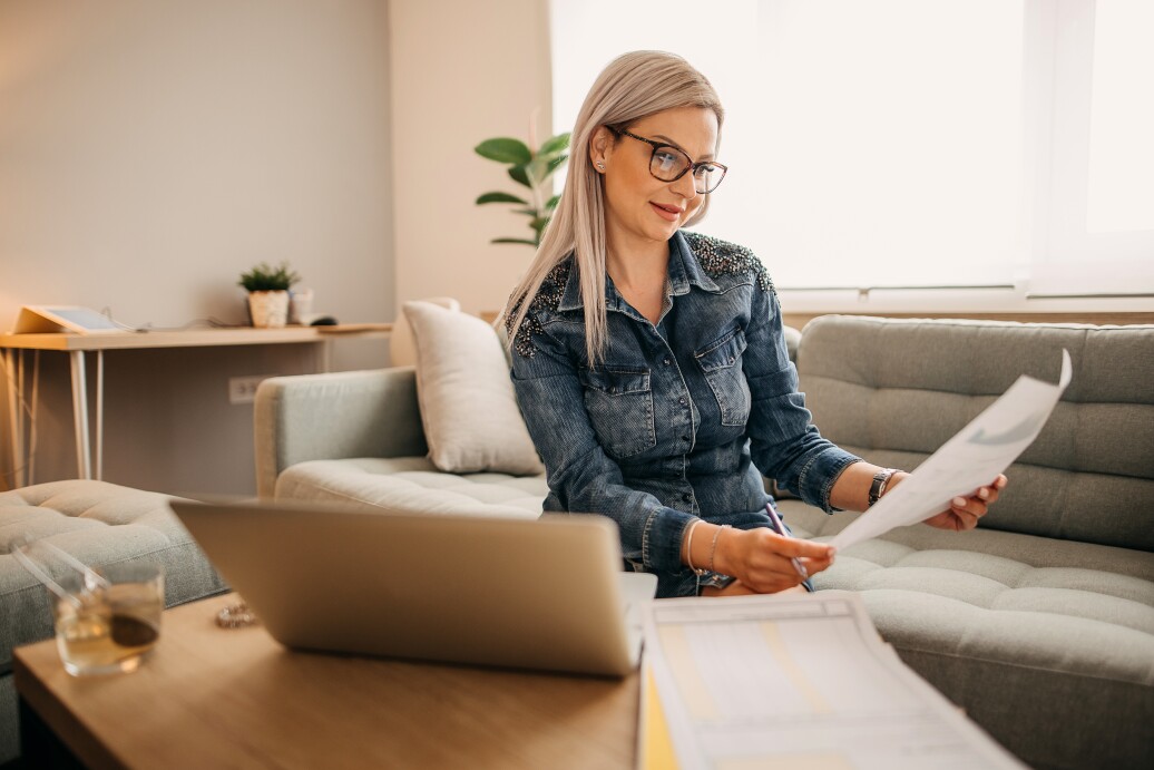 Woman working on couch with laptop