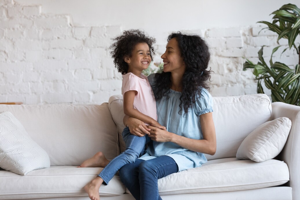 Happy millennial mom holding adorable joyful little daughter