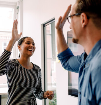 Coworkers about to high five in an office