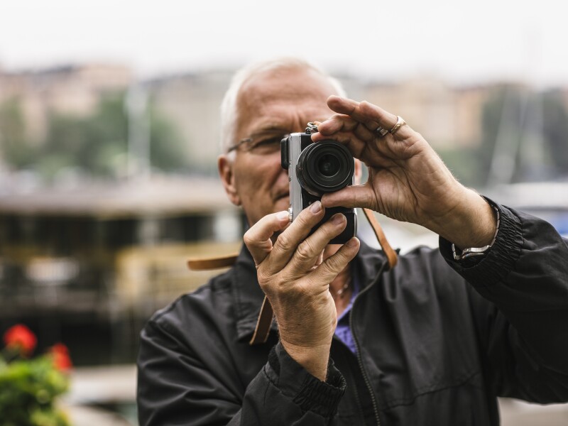Man in 60s using camera during photography course