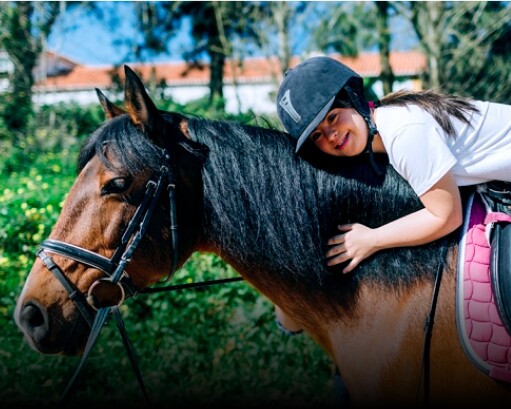 Young girl on horseback hugging the horse
