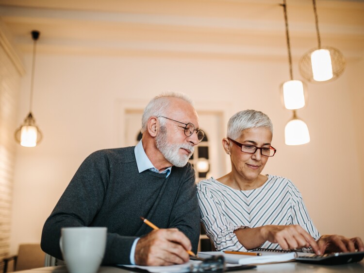 Mature couple doing some paperwork and calculations at home