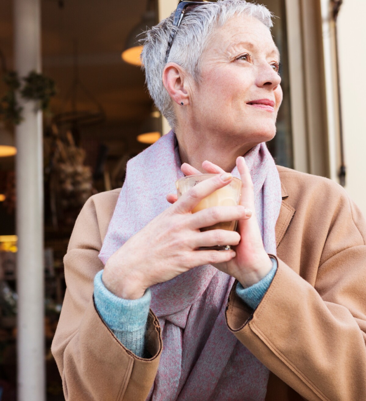 Contemplative female holding a cup looking out at the ocean