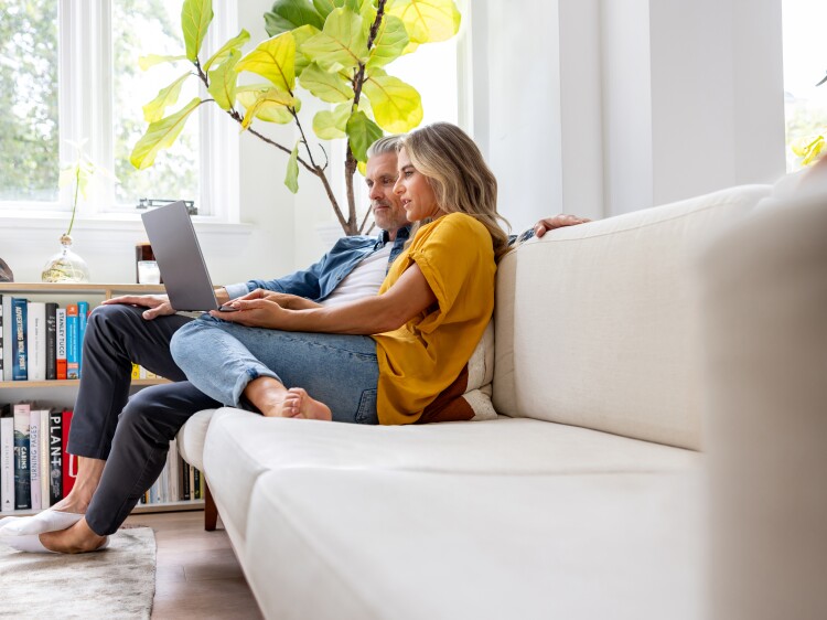 Couple on couch using laptop