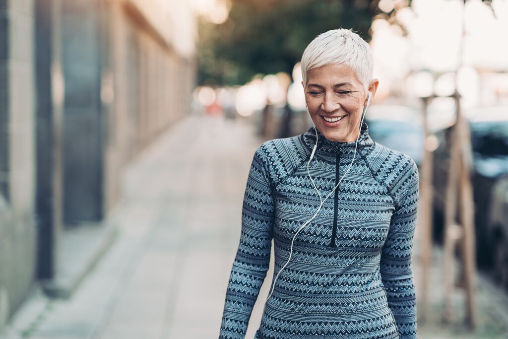 Senior woman walking with ear buds