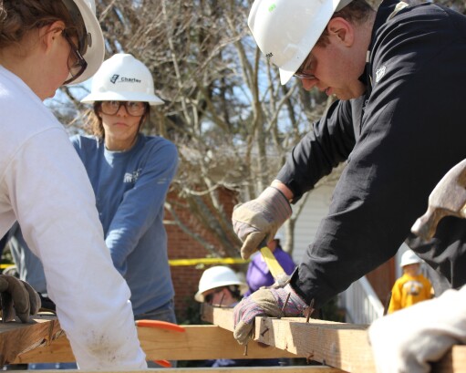 Team of workers builds the frame of a house