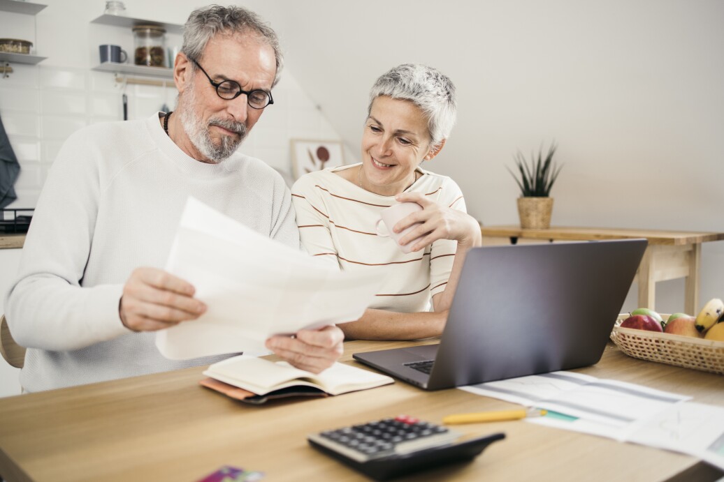 Portrait of a senior couple managing their finances together at home.