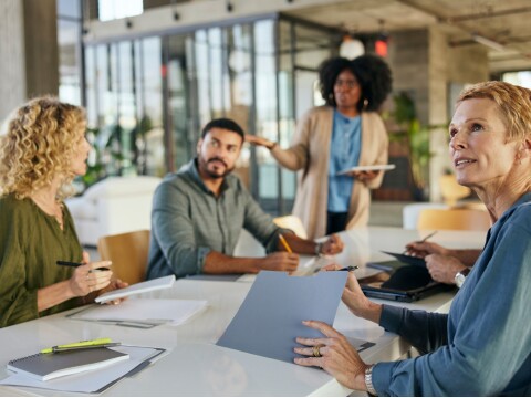 Four employees in a meeting, talking