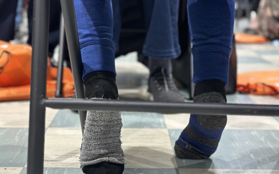 A student patiently waits for his new pair of athletic shoes.