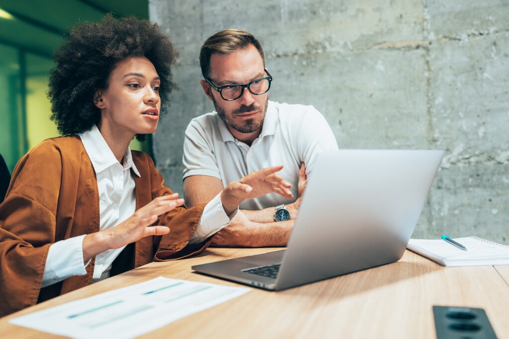Two people discussing what's on a laptop