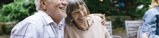Elderly couple enjoying outdoor meal with family
