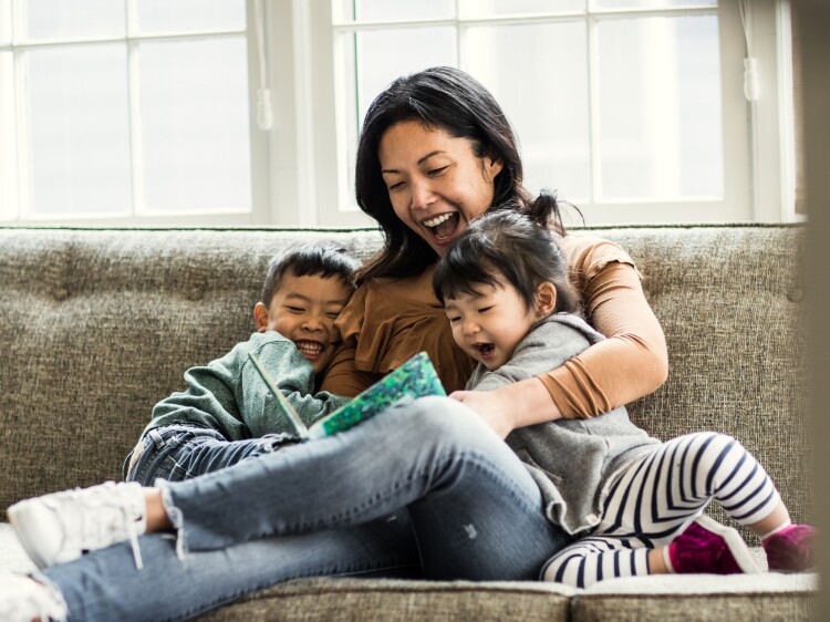 Mother reading to kids on couch