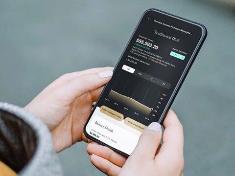 Hands holding mobile phone checking IRA account