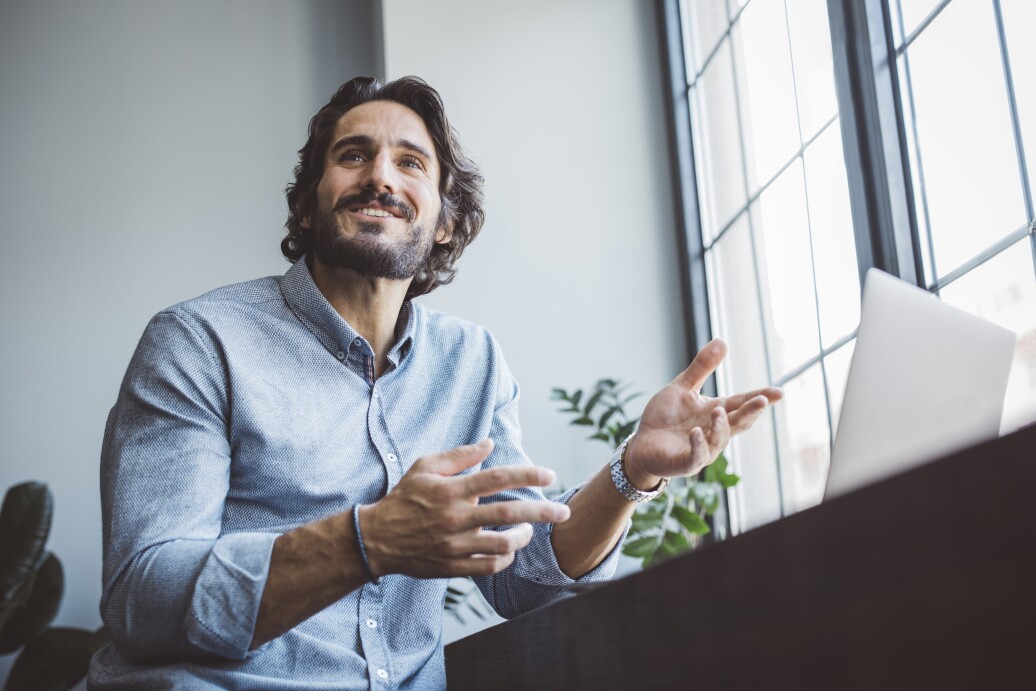 Man talking with hands using laptop
