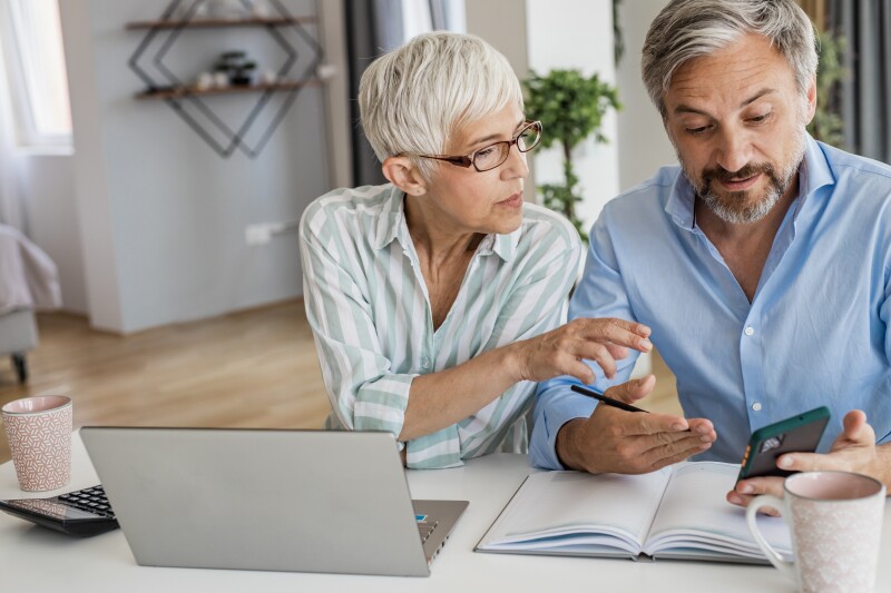 Mature couple using laptop at home