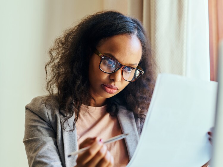 A young woman going through paperwork at home