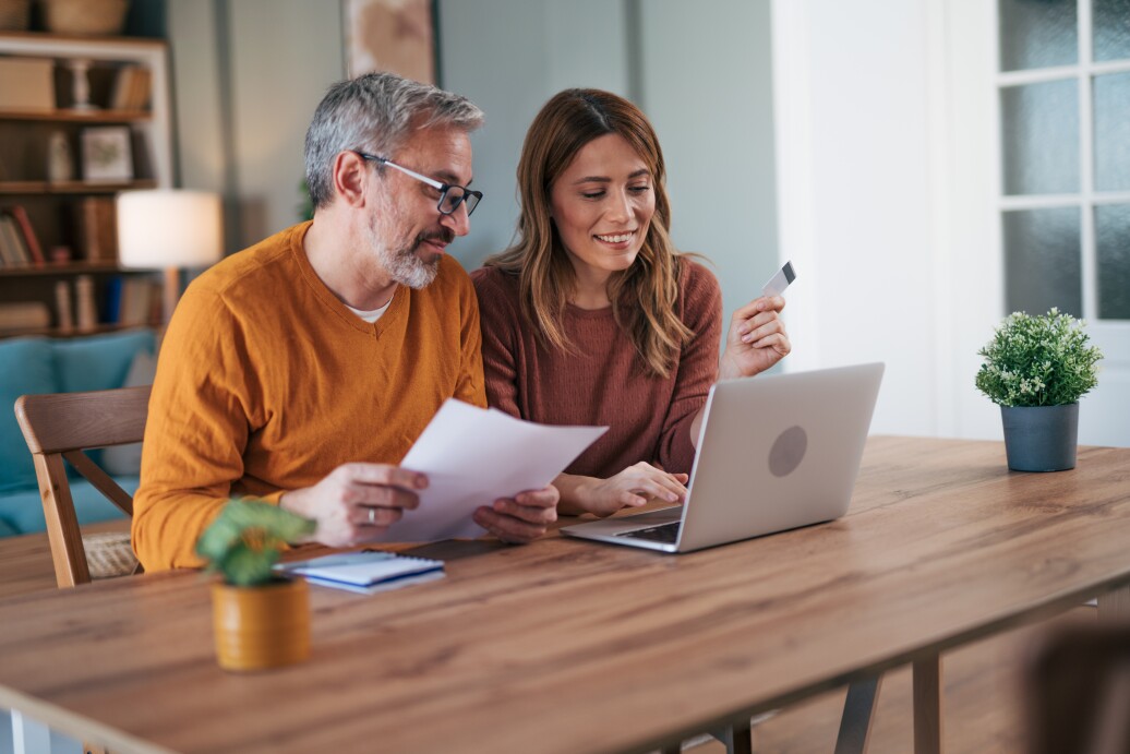 Shot of a couple using a laptop while doing their budget work in their dining room at home