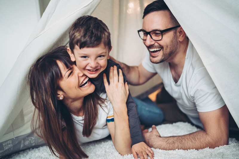 Happy loving family having fun together at home in a tent