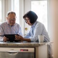 Senior couple using tablet on couch at home