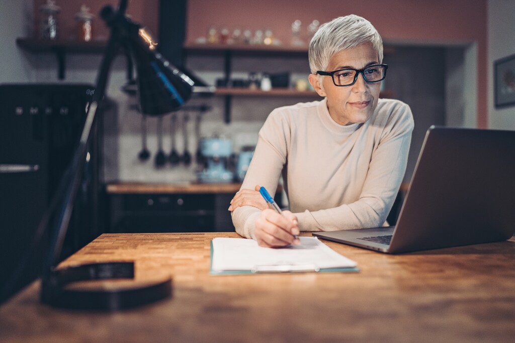 Mature woman doing paperwork at home