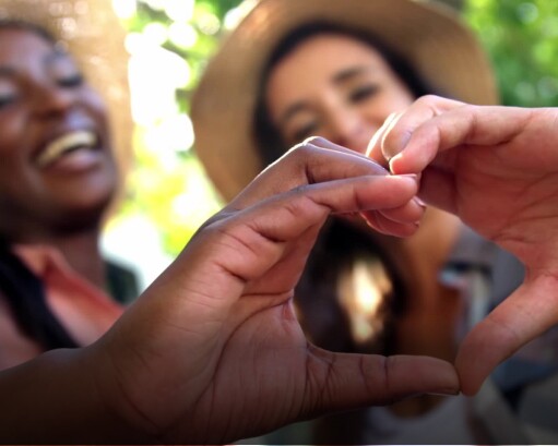 Two women shaping hands into a heart