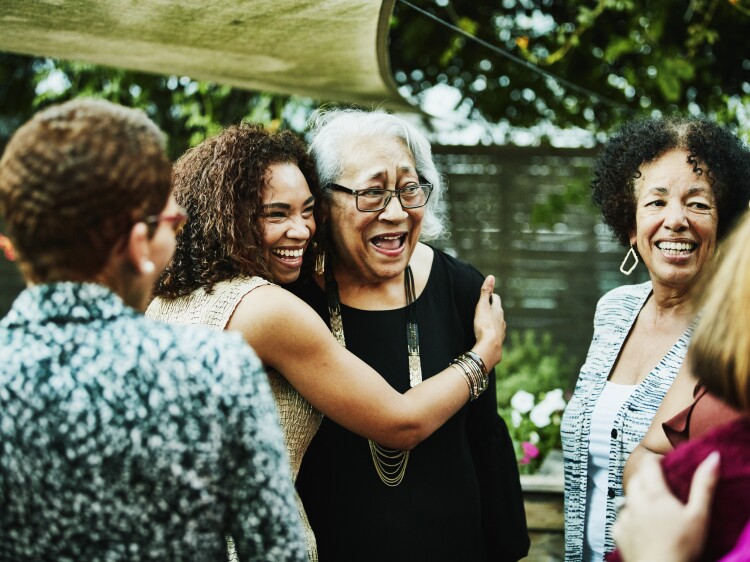 Daughter embracing senior mother after outdoor family dinner party