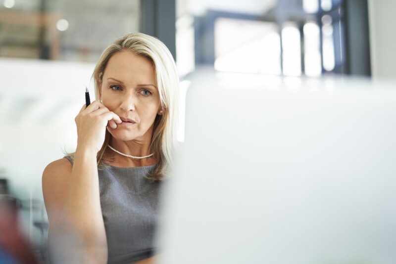 A woman sits at a computer.