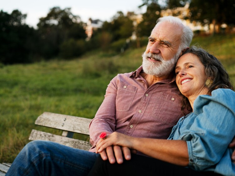Man and woman on bench, holding hands