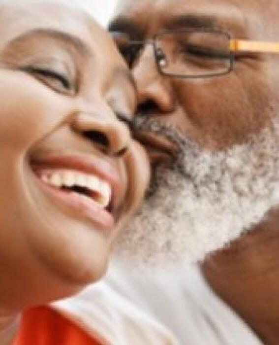 A happy couple, the man kissing the woman on the cheek