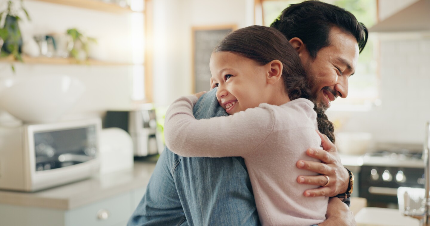 Family, father and daughter hug in the kitchen