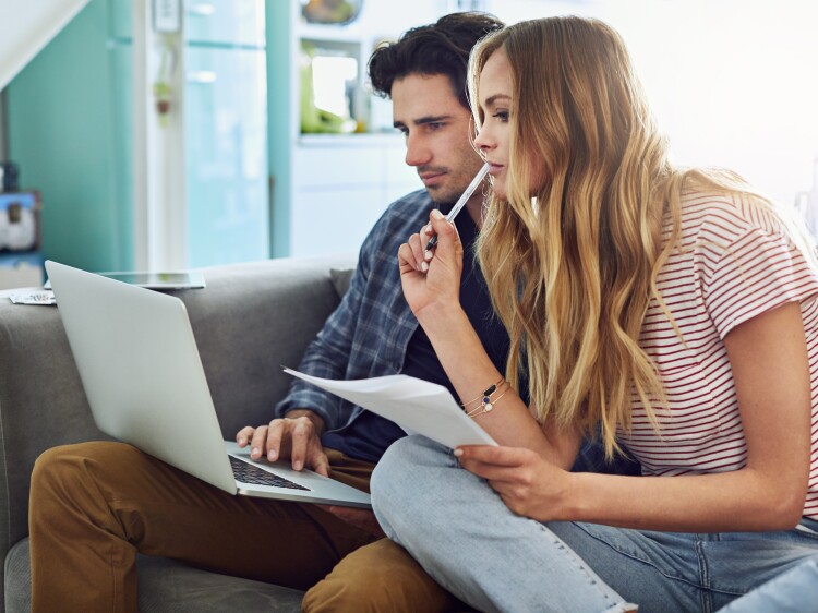 Photo of couple on couch looking at laptop