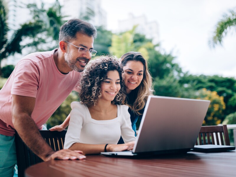 Family using laptop in the backyard
