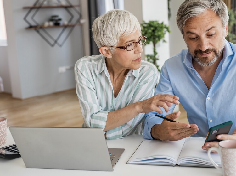 Mature couple using laptop at home