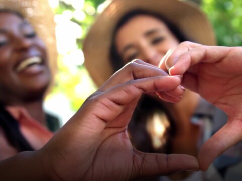 Two women shaping hands into a heart
