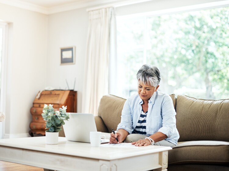 Shot of a woman doing paperwork at home