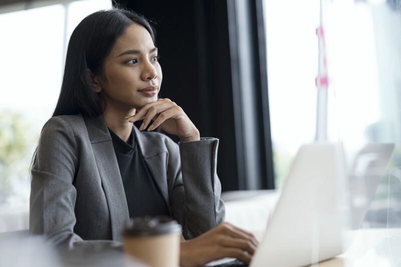 Young woman in blazer thinking