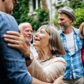 An elderly lady greeting some of her family members in a courtyard before a family meal.