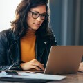 Asian business woman working on a laptop in a professional office