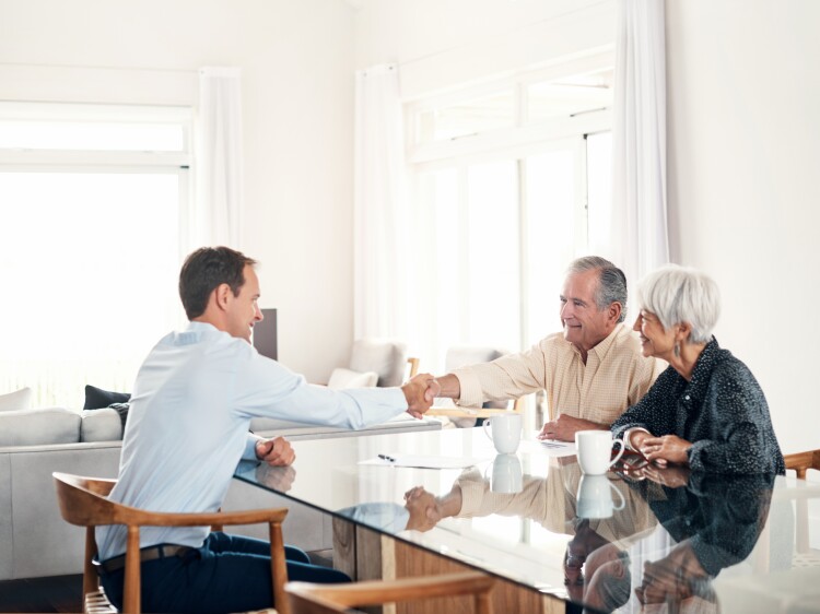 Senior couple meeting with their financial advisor at home