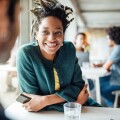 Smiling businesswoman sitting with colleague in cafeteria
