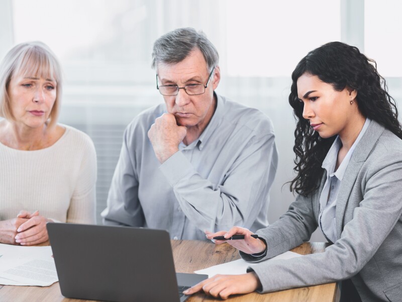 Mature couple talking to financial advisor at home
